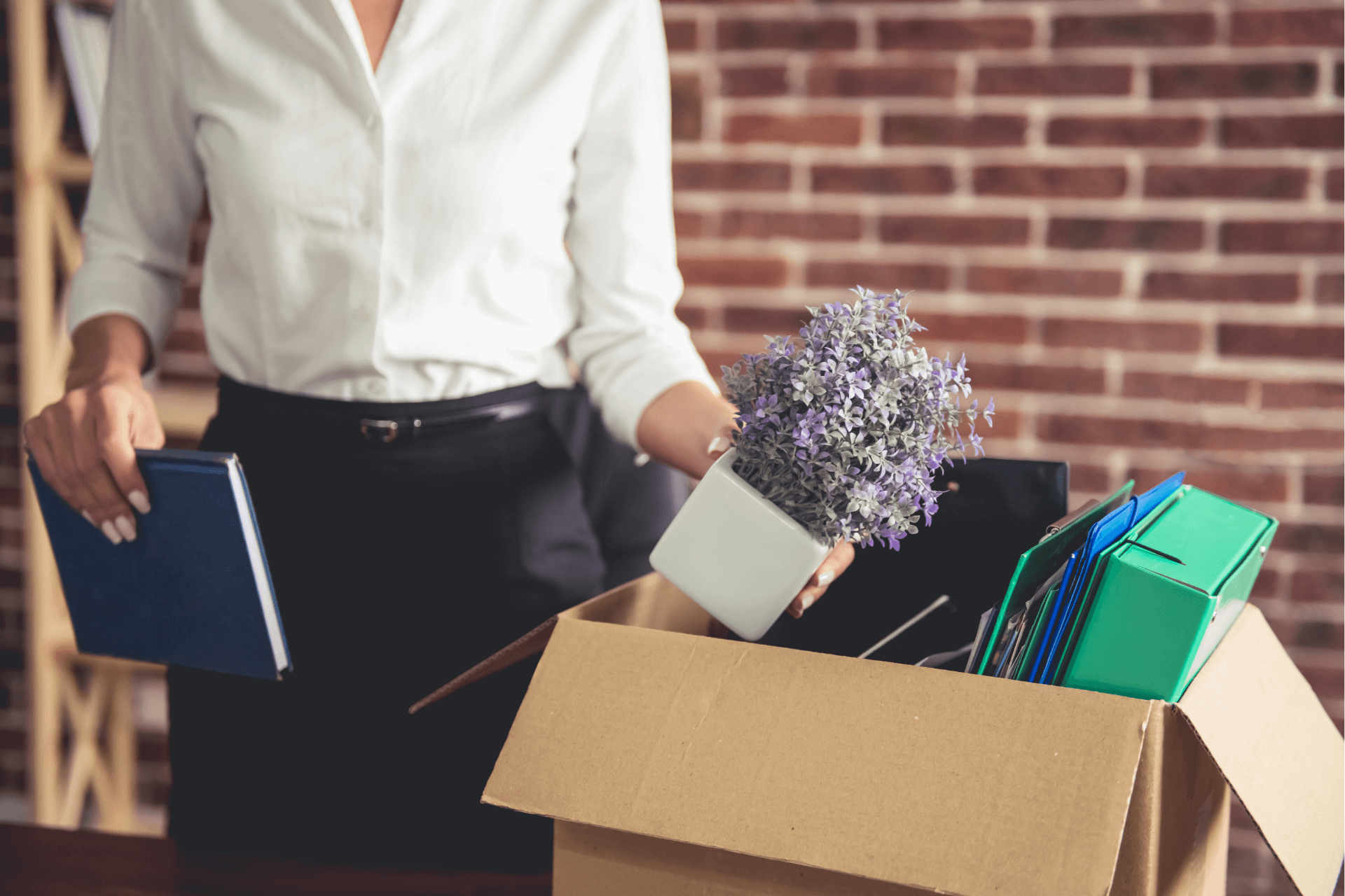 A woman packing up her desk after being fired